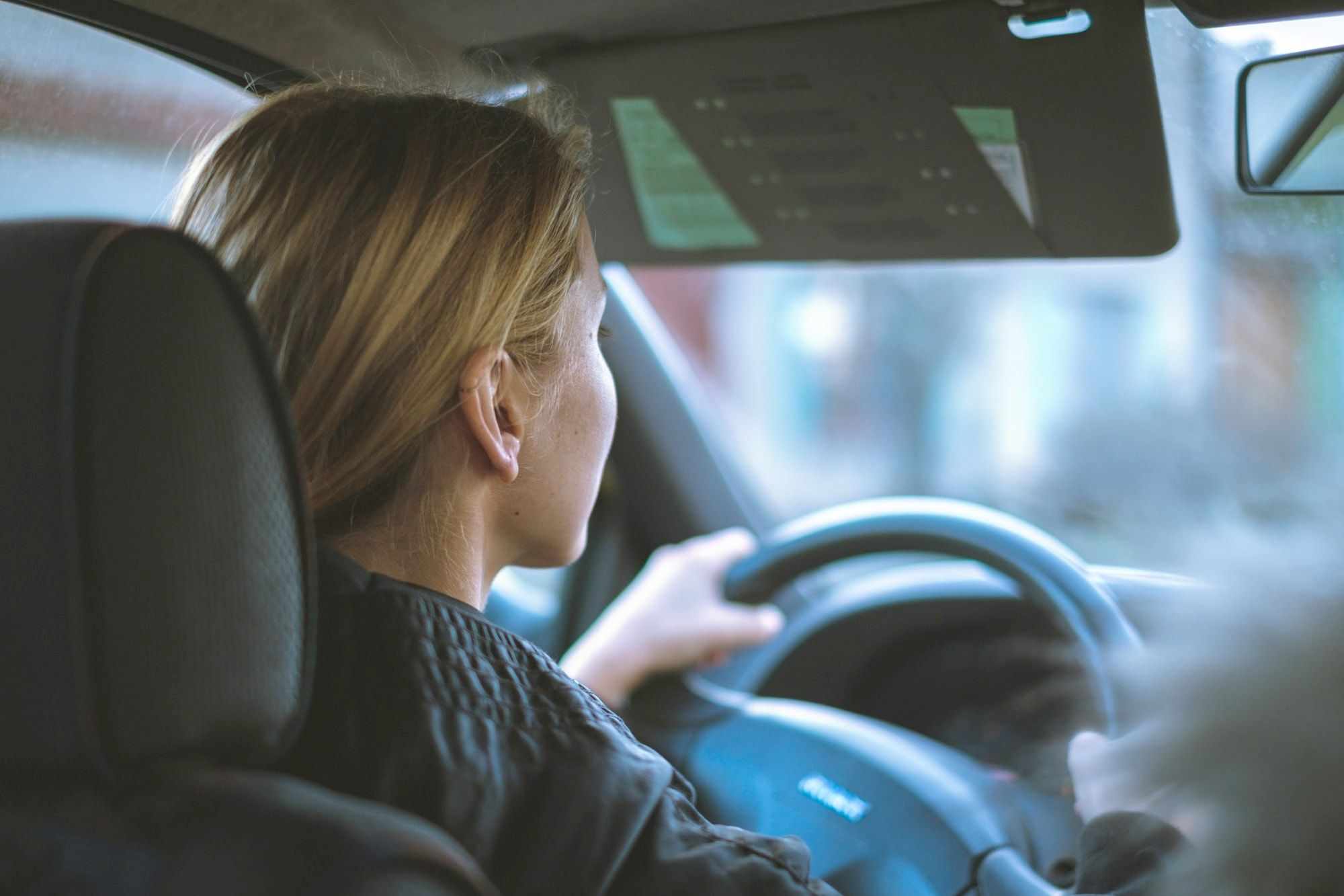 Mulher ao volante de um carro em movimento